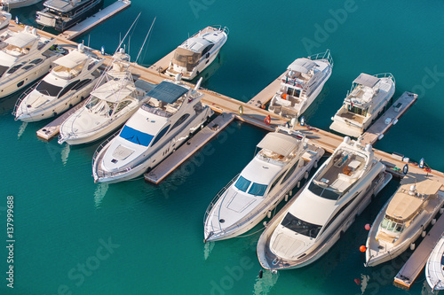 Aerial view of yacht club. White boats are in blue sea water.