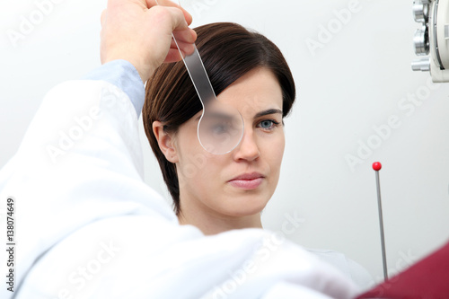 optometrist optician doctor examines eyesight of woman patient in eye ophthalmological clinic