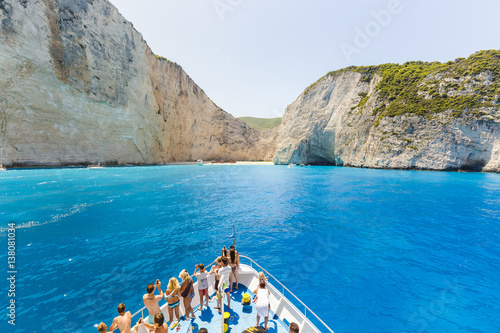 10 July 2016 Amazing landscape of Navagio beach with shipwreck on Zakynthos island, cruise ship with people on deck, approaching to the bay. Greece.