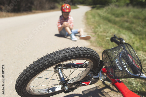 Boy is lying hurt after a bicycle accident. Kids safety concept