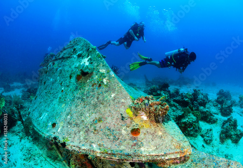 SCUBA divers around an upturned underwater wreck