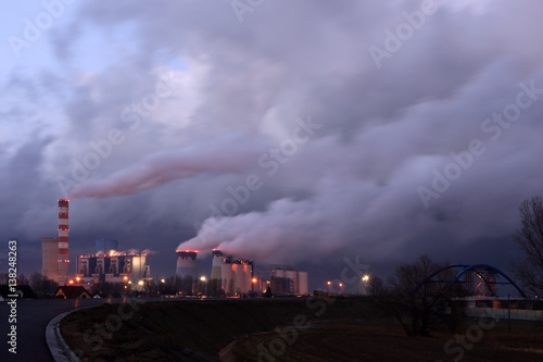 Dymiące kominy elektrowni węglowej w Opolu wieczorem.