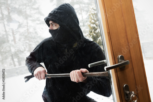 house robbery - robber trying open door with crowbar