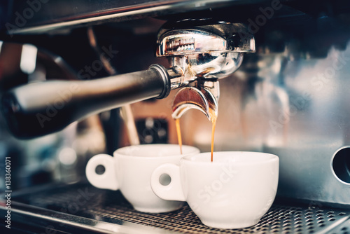 Profesjonalne parzenie - szczegóły baru kawowego. Kawa espresso leje się z ekspresu. Barista szczegóły w kawiarni