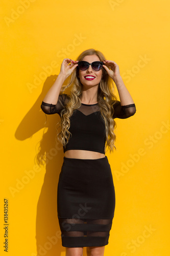 Elegant Woman In Black Dress And Sunglasses Looking Up