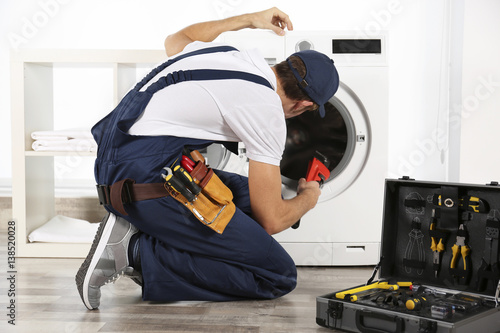 Plumber repairing washing machine