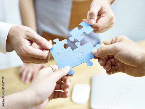 group of people putting jigsaw pieces together