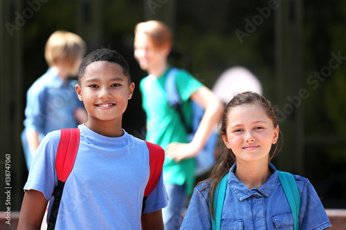 Cute kids standing near school