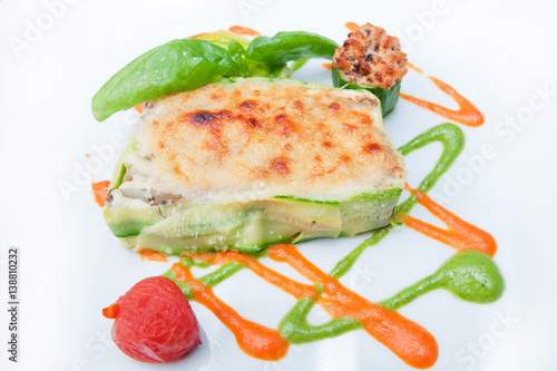 parmigiana zucchini gratin parmigiana zucchini gratin with mozzarella cheese; basil; tomato and decorated with lovely colored sauces