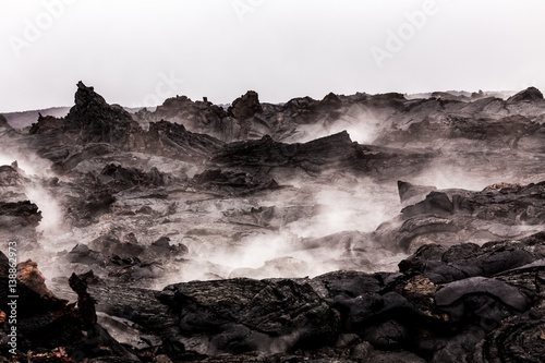 Steaming lava pieces under light rain