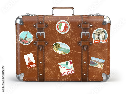 Old suitcase baggage with travel stickers isolated on white background.