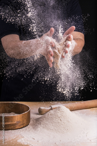 mani femminili che setacciano farina in cucina