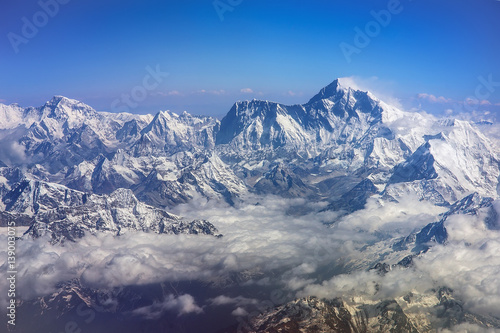 Himalaya mountains Everest and Lhotse, with snow flags and clouds, view from plane