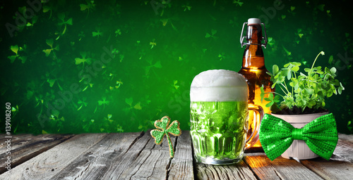 St Patrick's Day - Green Beer In Glass With Bottle And Clovers On Wooden Table 