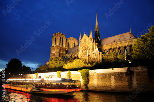 Paris, Notre Dame with boat on Seine at night