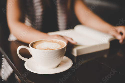 Asian woman relaxing and reading a book in the cafe. Women lifestyle concept.