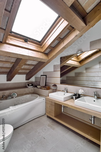 interior view of a modern bathroom in the attic room in foreground the countertop washbasin 