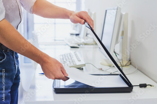 using scanner in office or library, closeup of hands scanning documents