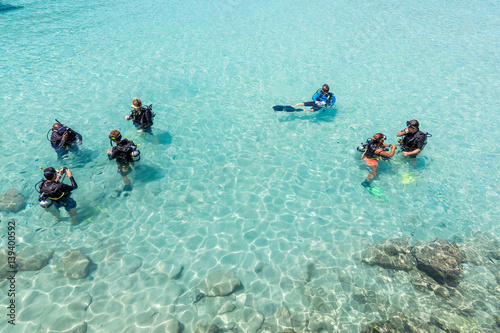 A group of Scuba Diving students have a lesson in shallow crystal clear water of a Tropical Island