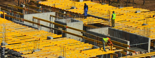 Construction workers installing mounting horizontal formwork on the building construction site.