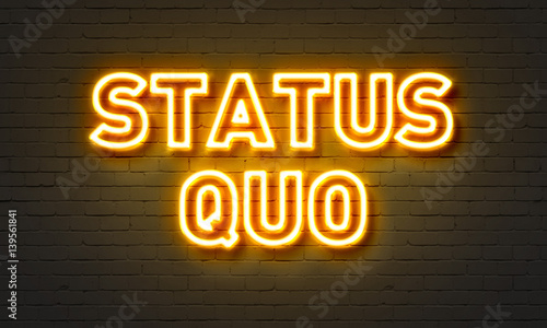 Status quo neon sign on brick wall background.