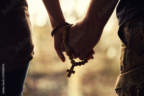 Holding rosary in hand.