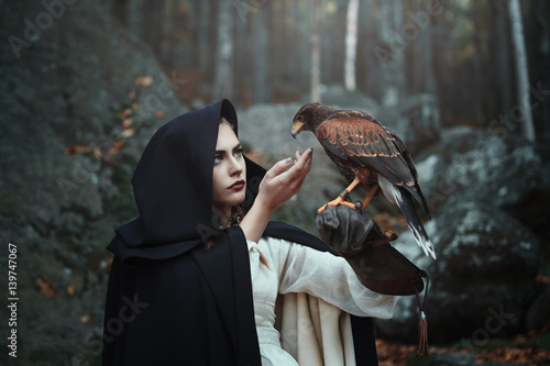 Black hooded huntress with hawk