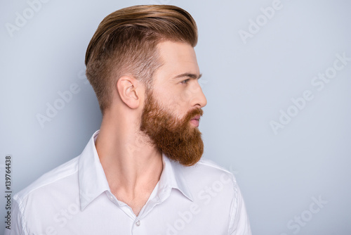 Bocznego widoku portret ufny brodaty mężczyzna patrzeje na kopii przestrzeni z piękną fryzurą w białej koszula