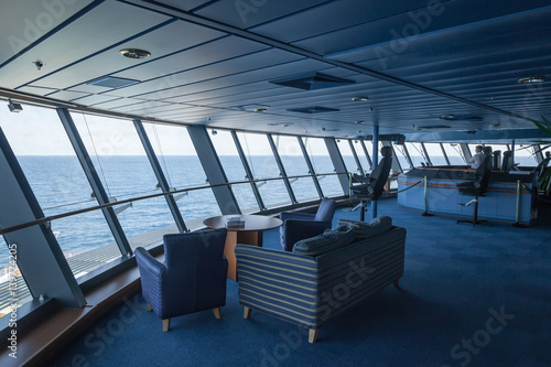 View from port wing looking towards helmsman position on bridge of large modern passenger cruise liner.