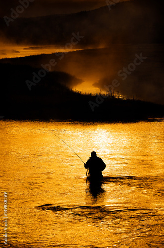 Silhouette of Man Flyfishing in River