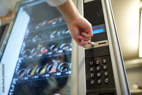 hand pushing button on vending machine