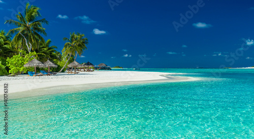 Palmy i parasole nad laguną i białą piaszczystą plażą, Malediwy