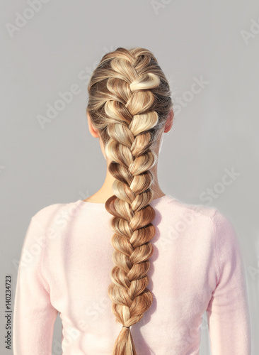 Young beautiful woman with nice braid hairstyle on light background