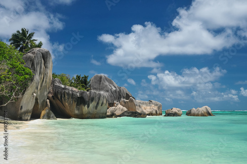 Big granite stones on the white-sand beach next to turquoise water