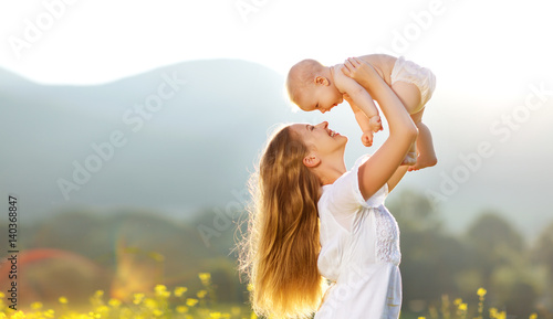 Happy family mother and baby son in nature in summer