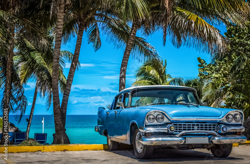 Blauer amerikanischer Oldtimer parkt am Strand unter Palmen in Varadero Kuba - Serie Kuba Reportage