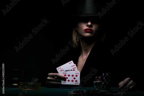 Beautiful young woman playing poker