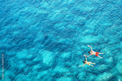 Drone view of couple snorkeling in sea water