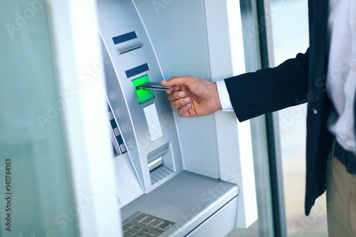 Close-up Of Person Using Credit Card To Withdrawing Money From Atm Machine