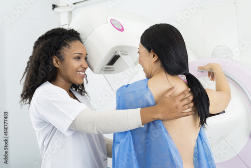 Happy Doctor Assisting Woman Undergoing Mammogram X-ray Test