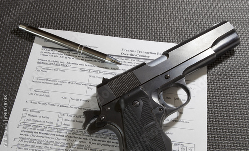 Semi-auto pistol on top of the 4473 firearm transfer paperwork to get an FBI background check to buy it.