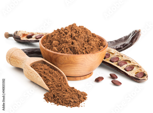 Ground carob and pods isolated on white