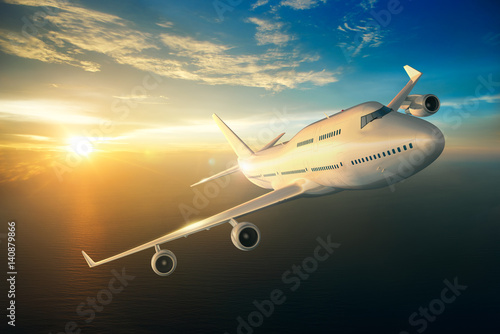 Airplane flying over the sea during sunset