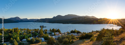 Panoramiczny widok na jezioro Lac de Serre Poncon we francuskich Alpach i kemping z zachodem słońca