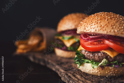 two mouth-watering, delicious homemade burger used to chop beef. on the wooden table.