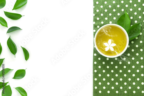 Top view shot of a hot cup of tea with green leaf decoration with green napkin on white background , Organic green Tea ceremony time concept