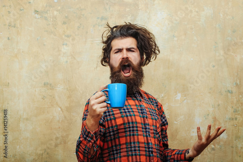 singing bearded man pulling stylish fringe hair with blue cup