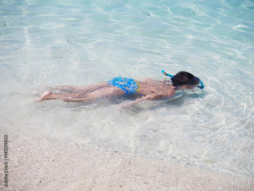 Asian boy diving underwater on summer beach.