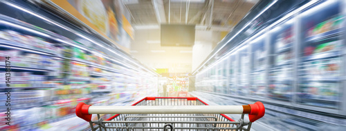 Supermarket aisle with empty red shopping cart