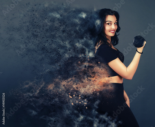 Belle femme sportive tenant une haltère sur un fond gris avec un effet de dispersion 